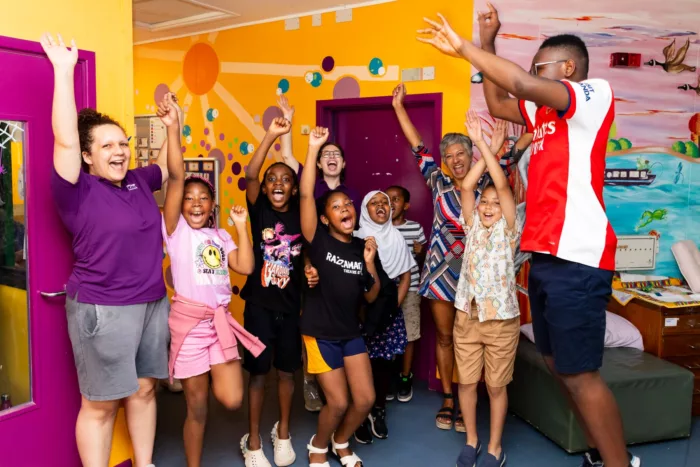 group of children cheering with their hands in the air