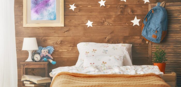 girl's bedroom with orange bedding and wooden walls